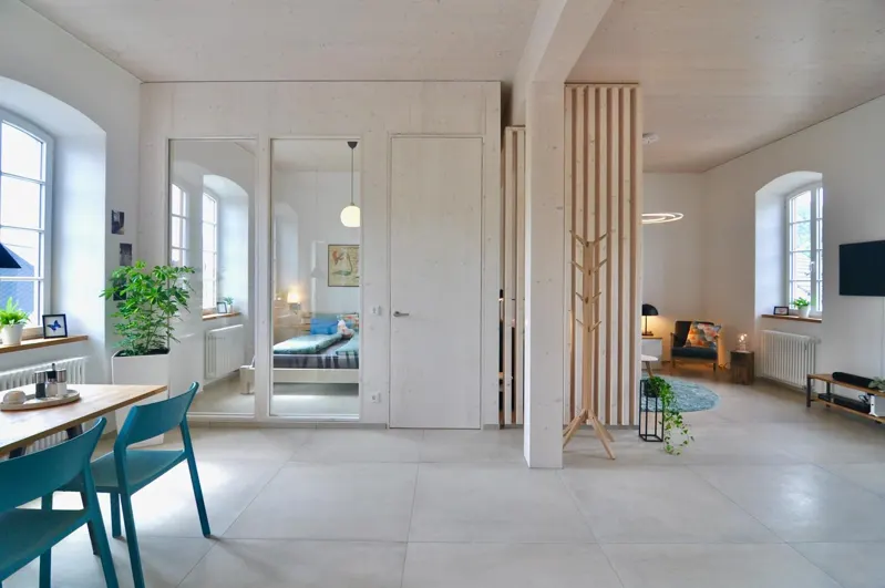 Renovated interior with dining area, doors and wood slat partition