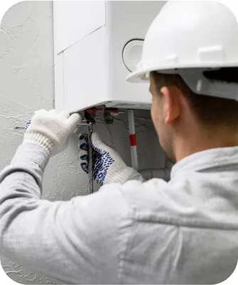 Technician working on a wall-mounted heating unit.
