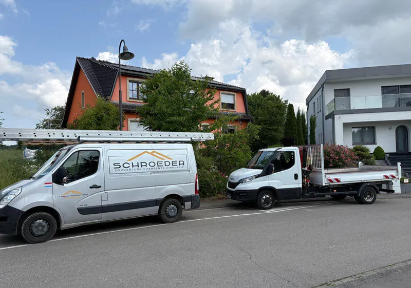Deux véhicules d’entreprise marqués garés dans une rue.