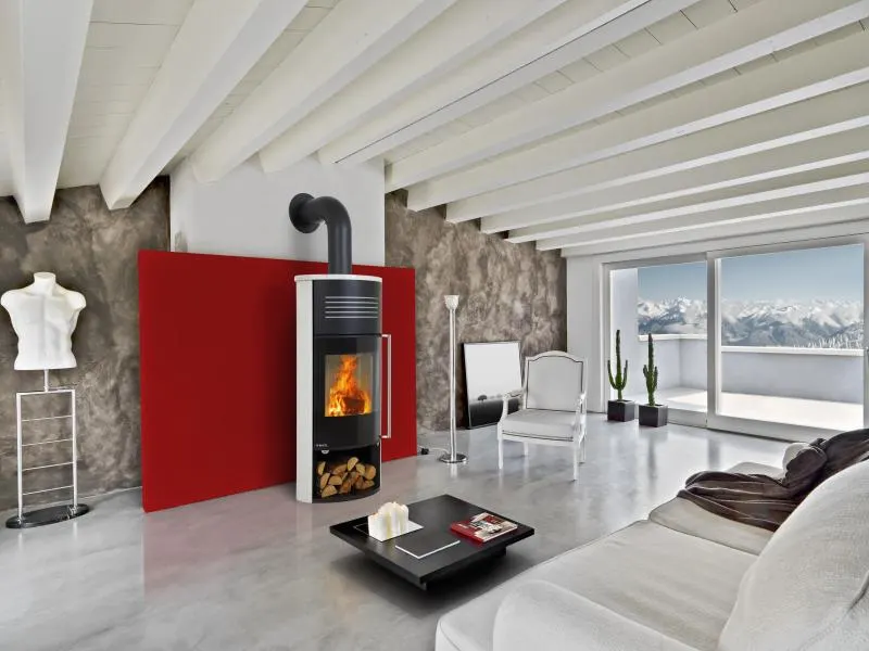 Freestanding wood stove with a visible fire in a living room.