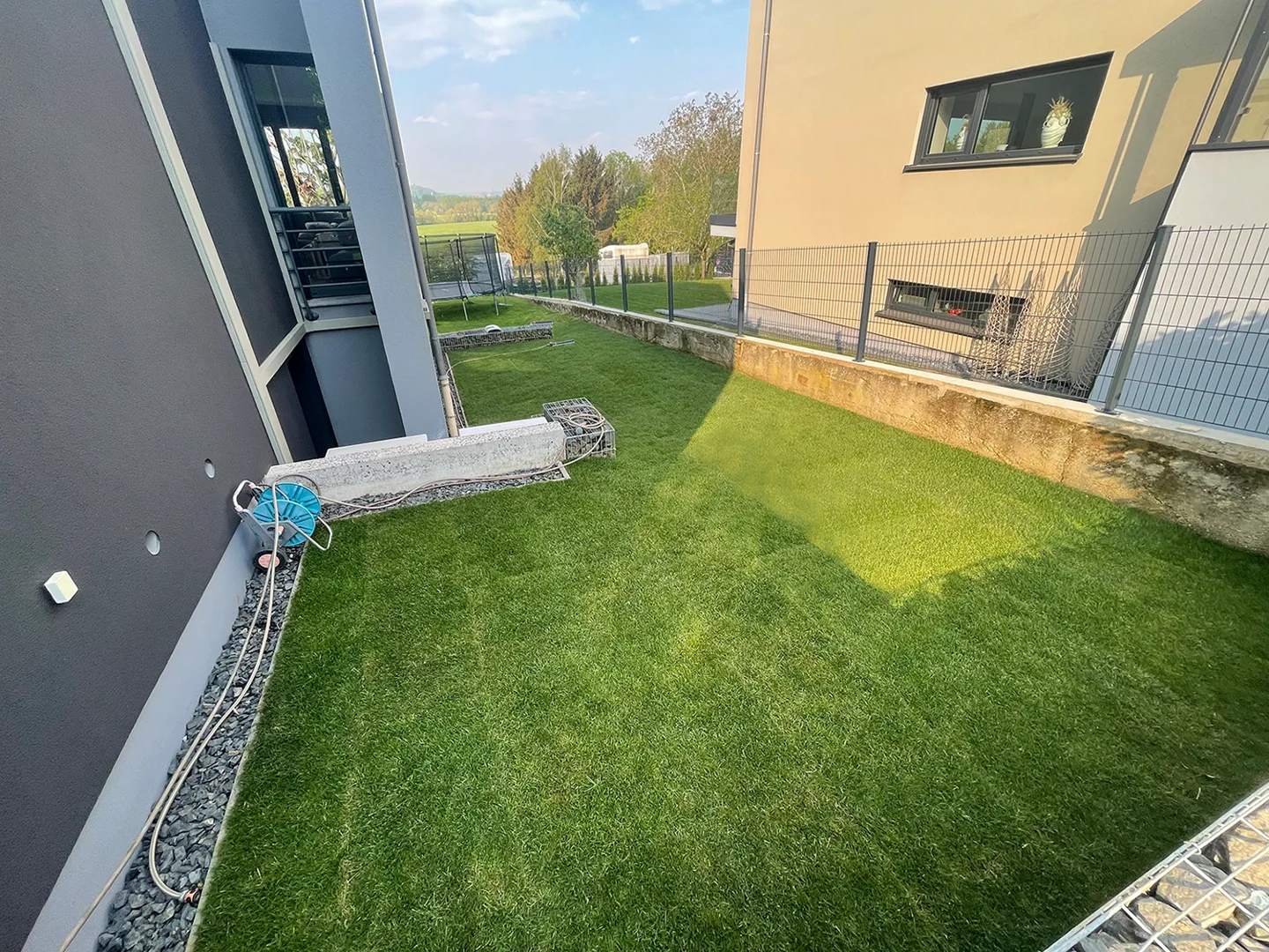 Rolled turf being laid beside a house