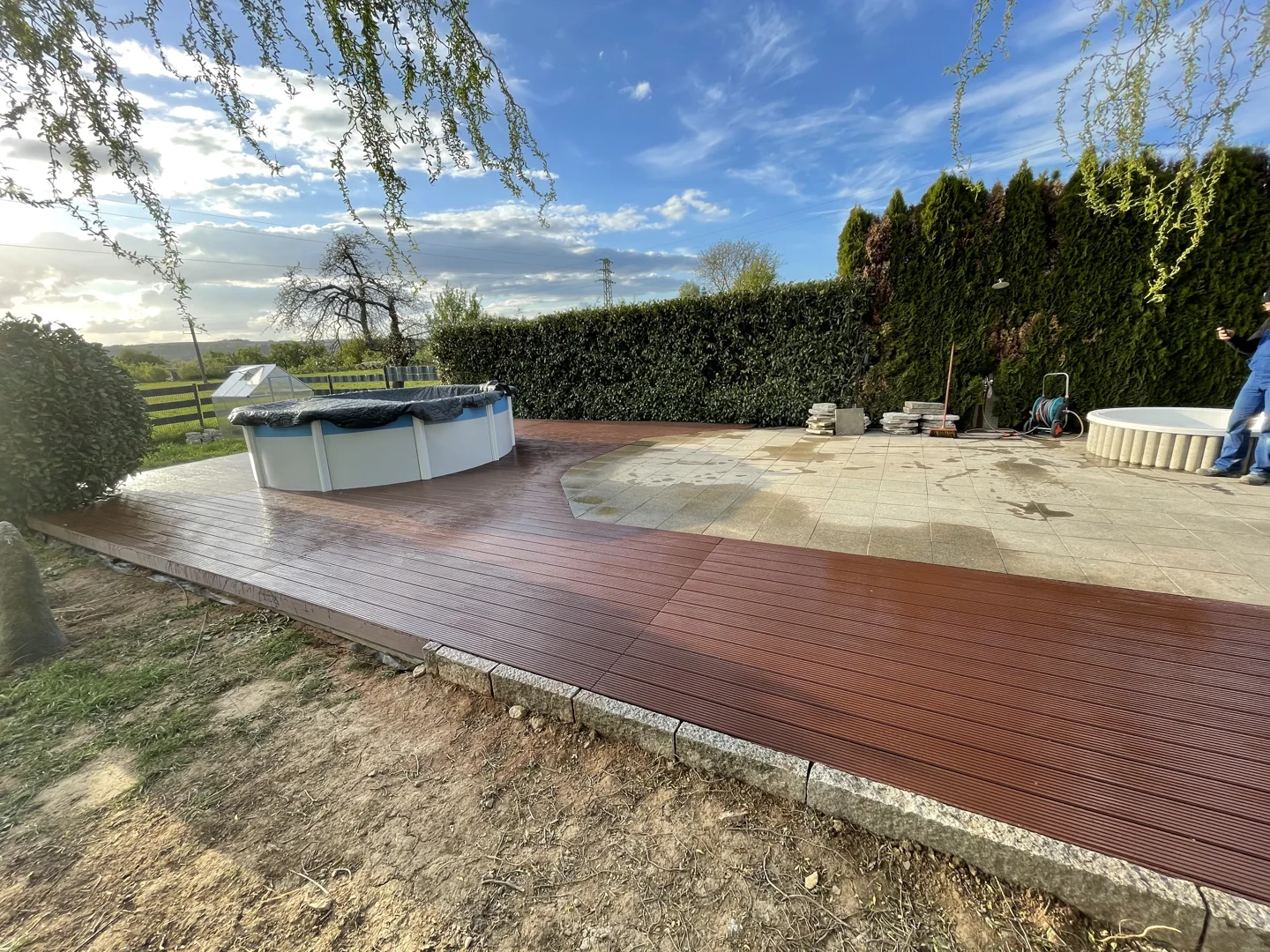 Wooden deck terrace framed by a hedge
