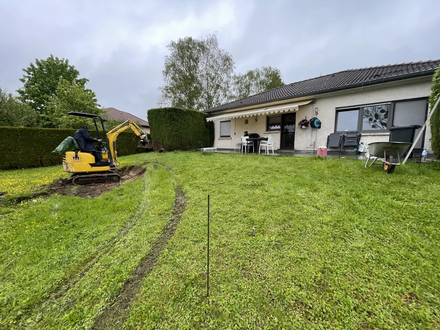 Mini excavator preparing a garden behind a house