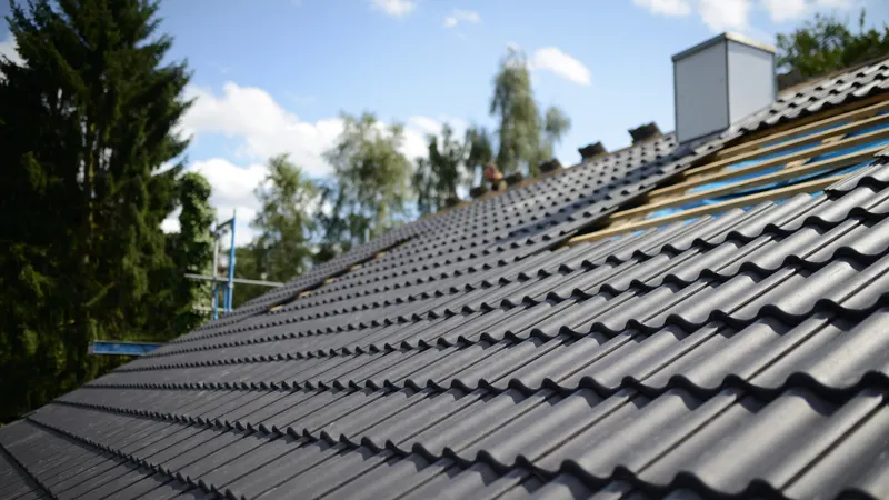 Close view of a tiled roof with a chimney.
