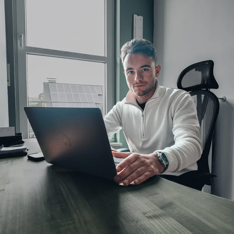 A person working at a laptop in an office.