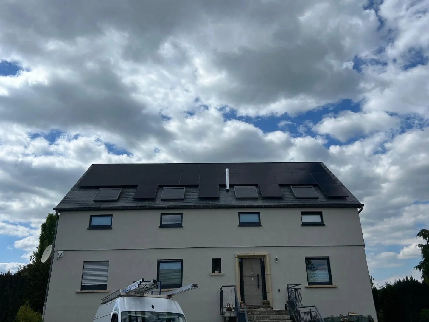 Panels on the roof of a grey rendered house