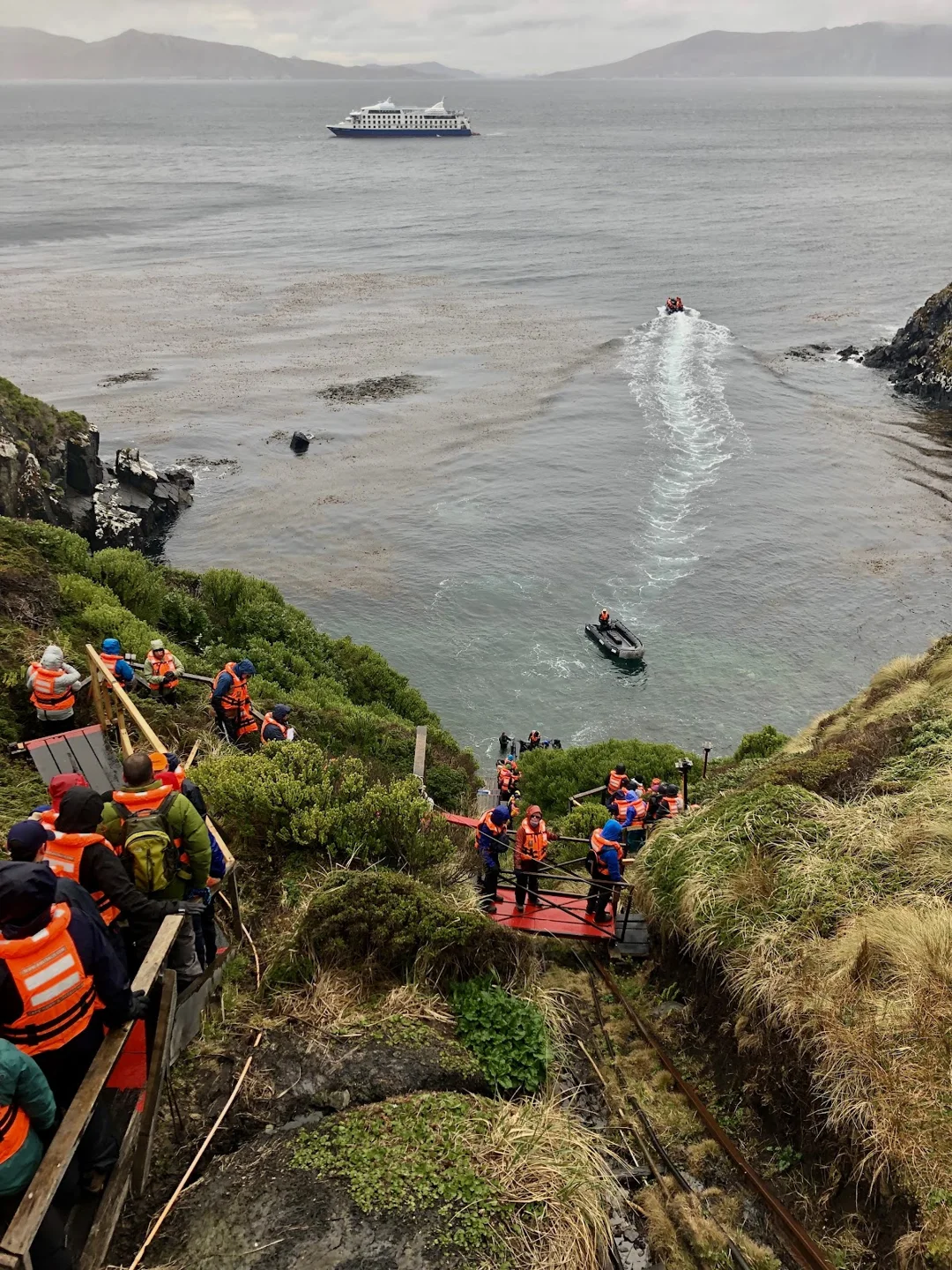 Expeditionsgruppe auf einem Küstenpfad über der Bucht