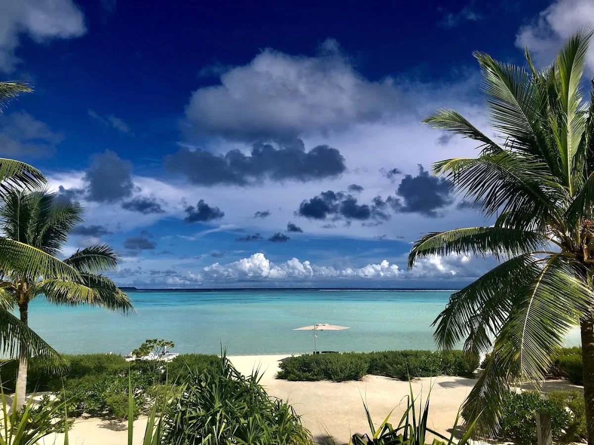 Palmenstrand und Lagune unter tropischem Himmel