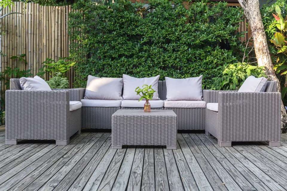 Outdoor seating on a wooden terrace surrounded by greenery.
