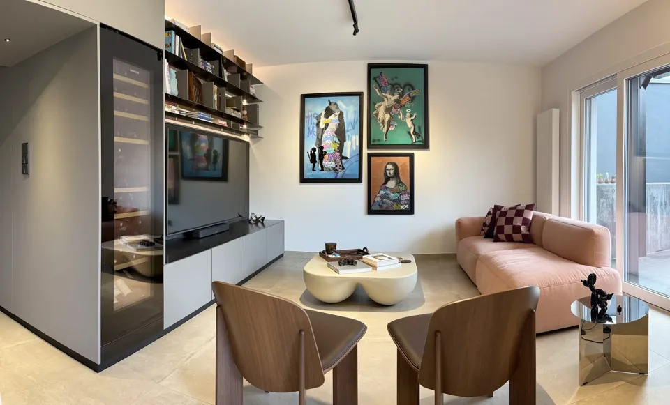 Living room with built-in shelving, seating and a dining area.