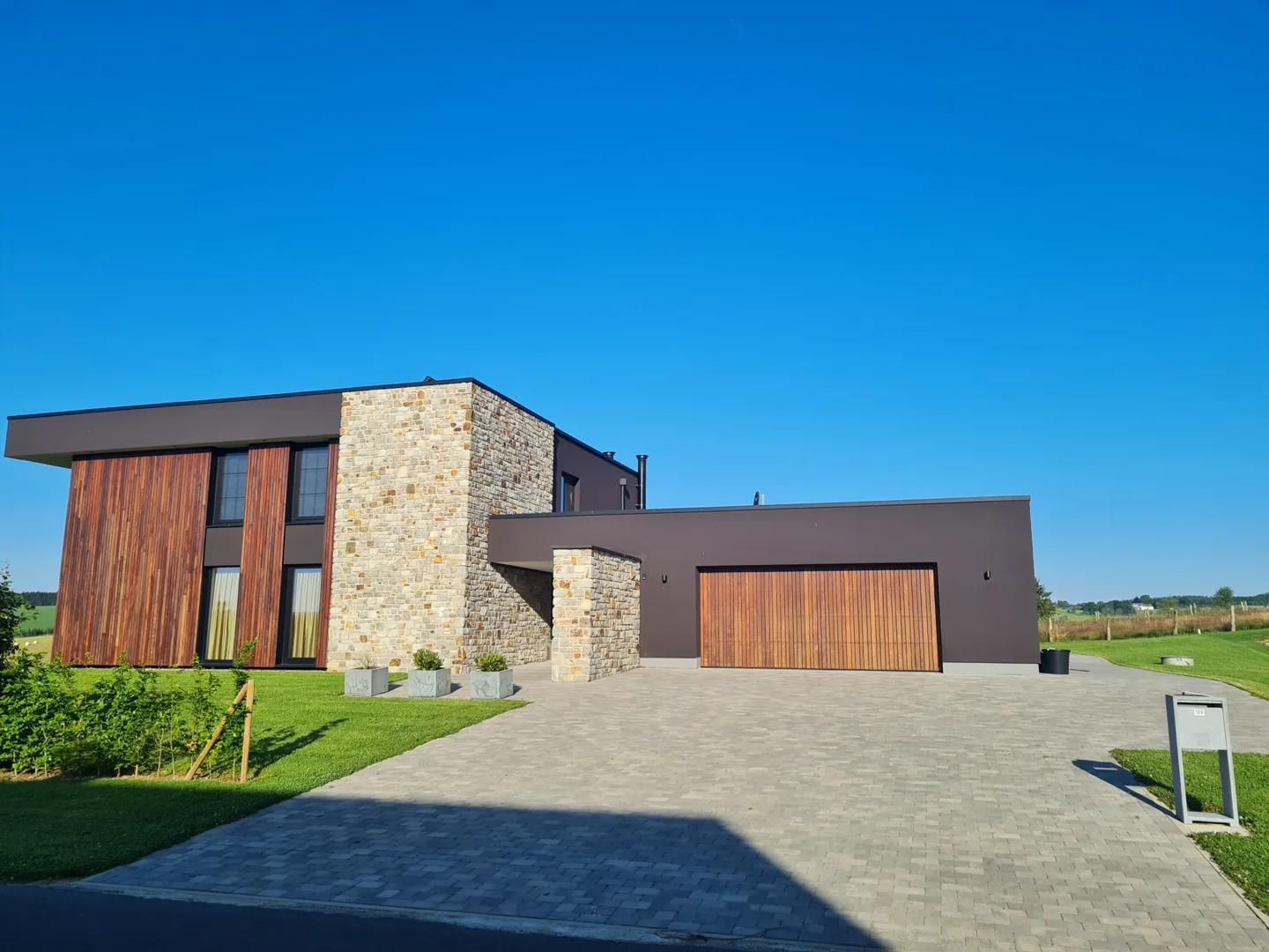 Modernes Haus mit verputzten Wänden, Holzverkleidung und Natursteinfassade