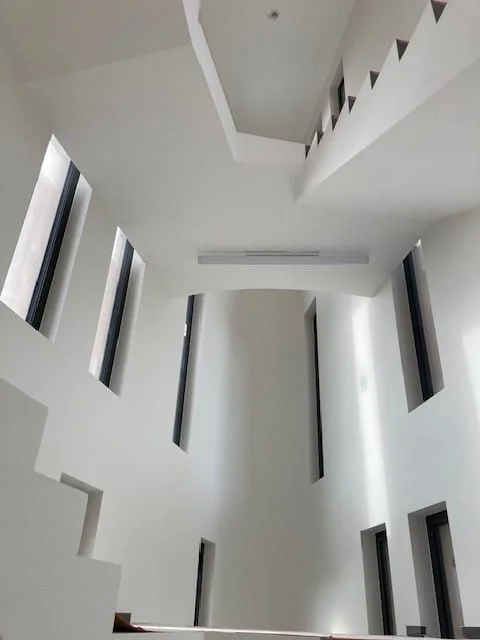 Cathedral-style staircase well painted white