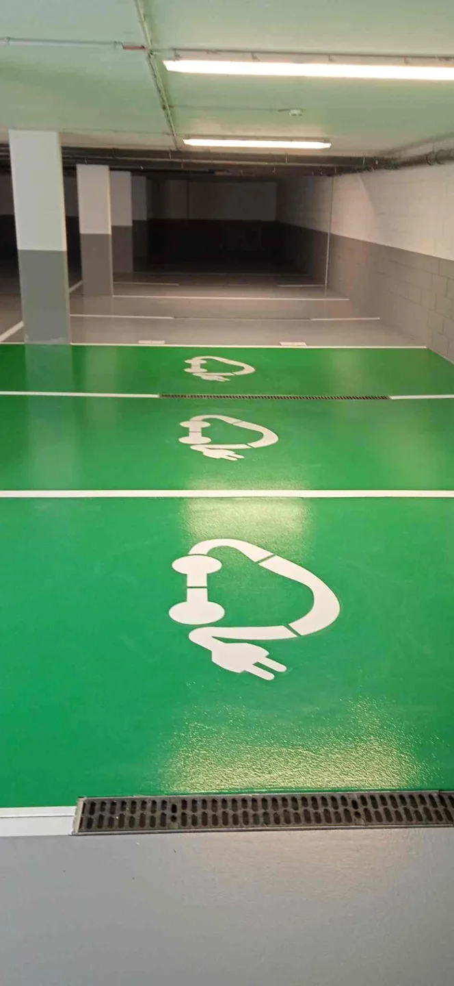 Charging-bay pictogram painted on a green floor
