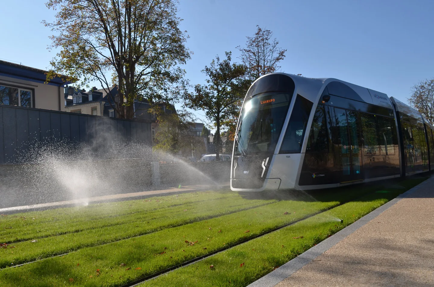 Sprinklers watering the lawn track beside the tram in Luxembourg City