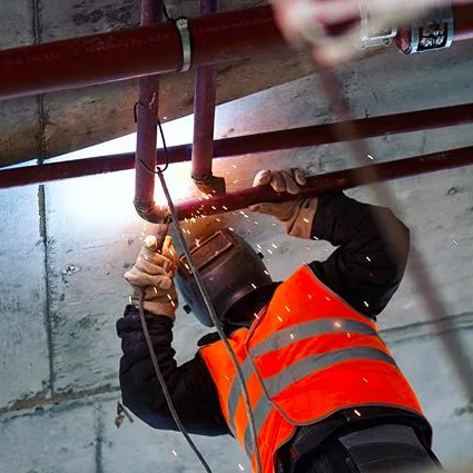 Schweißarbeiten an Rohrleitungen über Kopf auf einer Baustelle