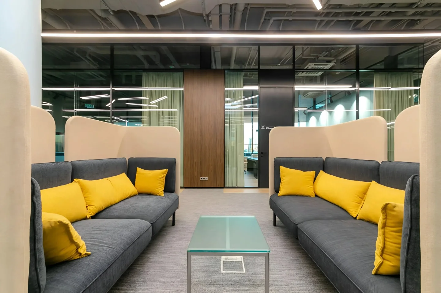 Ausgebaute Büro-Lounge mit Sofas und Glastrennwänden