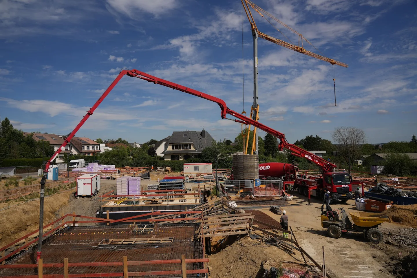 Betonpumpe und Kran auf einer Hausbaustelle, Fundamente im Bau