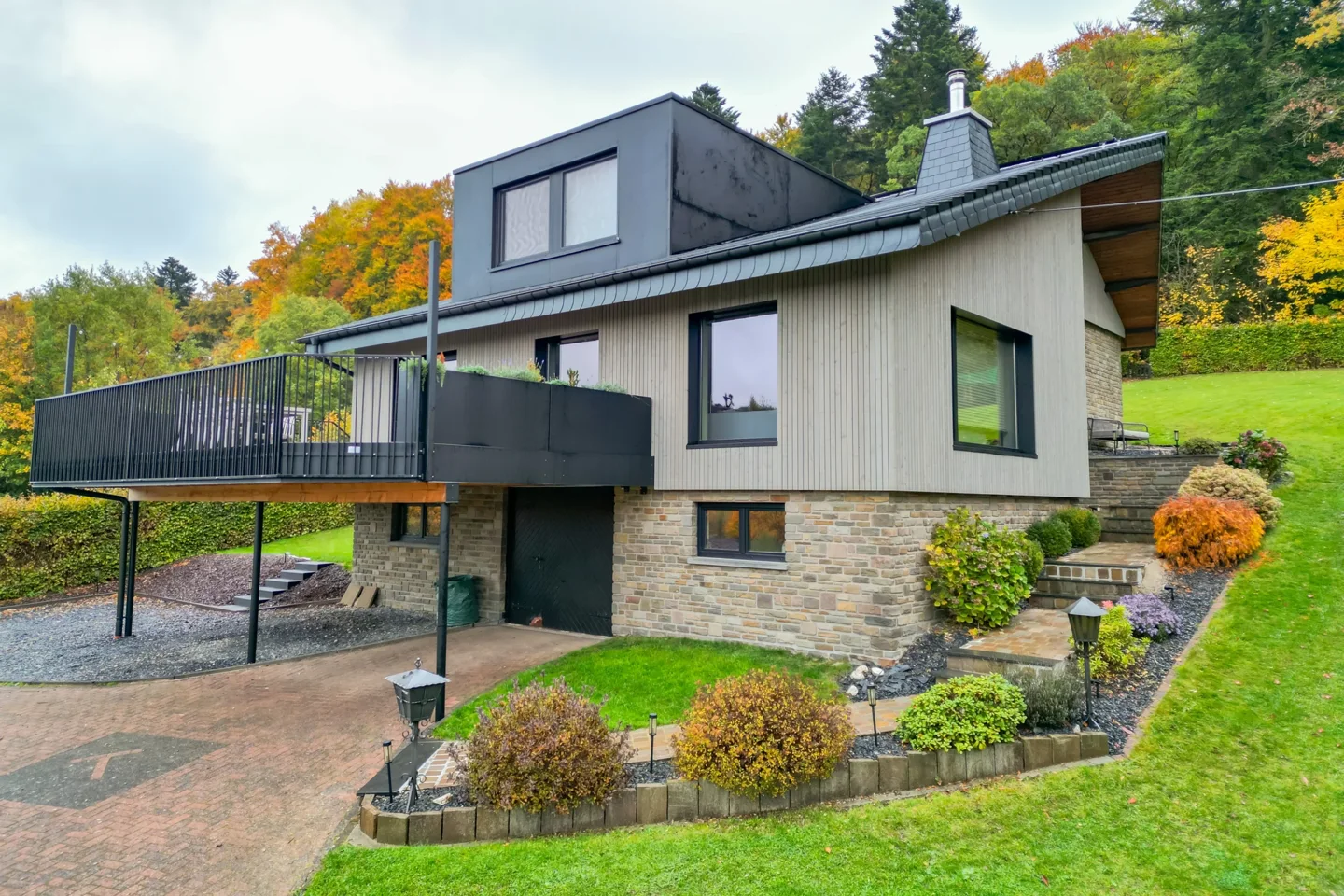 Ventilated façade in grey spruce boards with natural stone