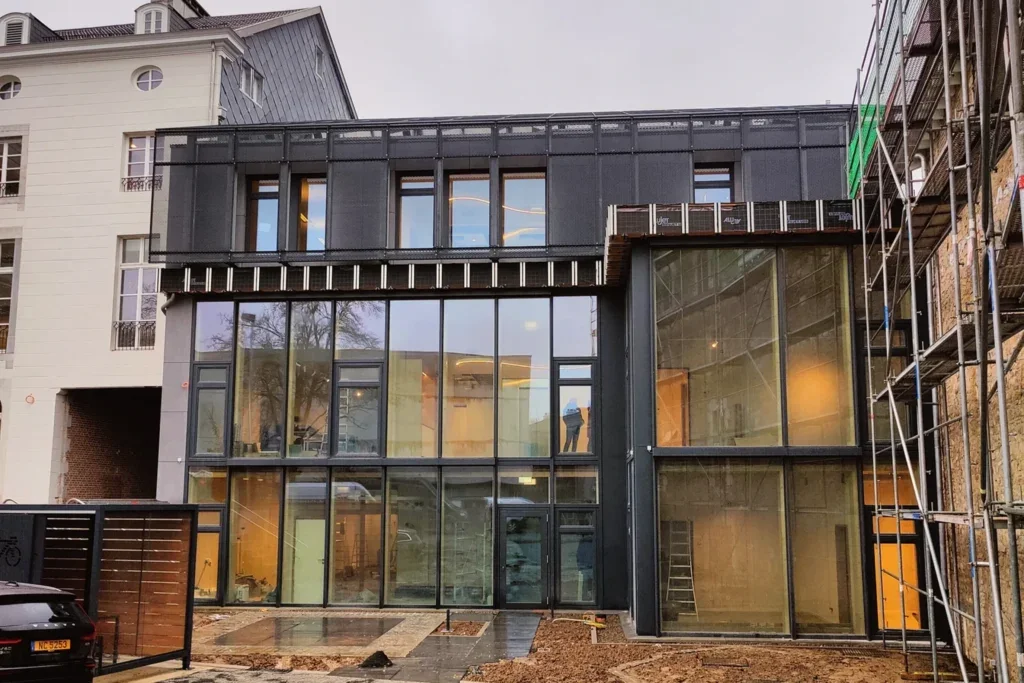 Old building converted into offices, with the new metal structure on the roof
