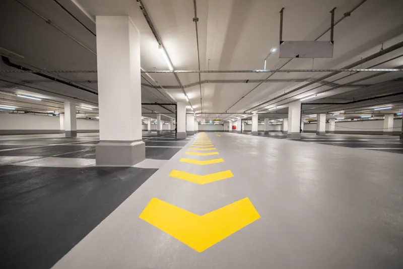 Underground parking area with yellow directional markings.