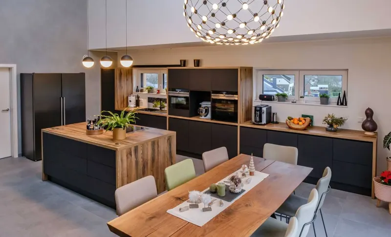 Modern kitchen with a wood island, dark cabinetry and dining area.