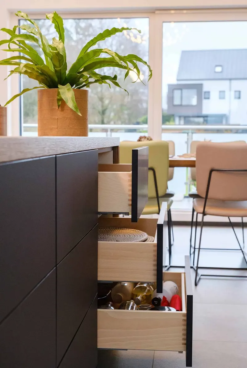 Open kitchen drawers beside a dining area.