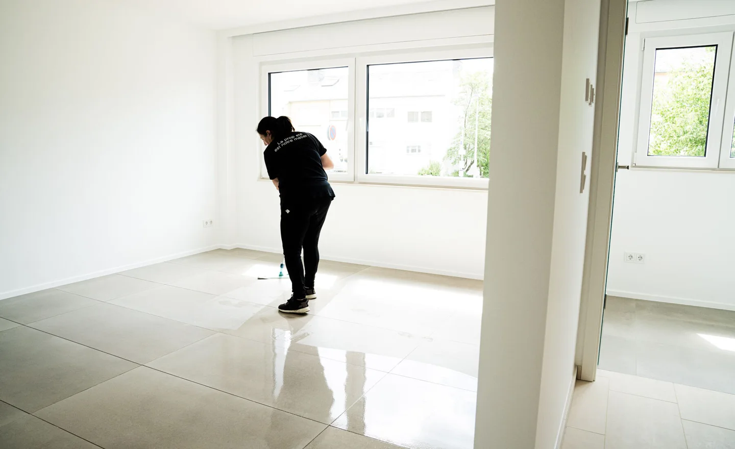 Housekeeper cleaning the floor of a bright apartment