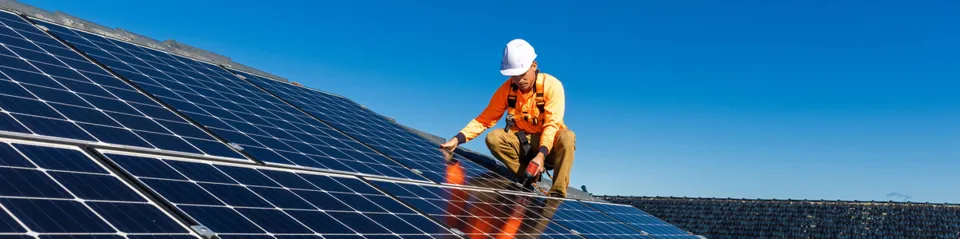 Worker installing photovoltaic panels.